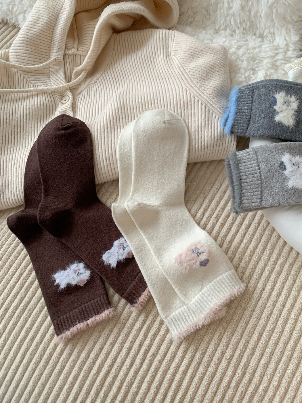 Brown, ivory and gray animal-motif crew socks arranged to show the soles and cuffs