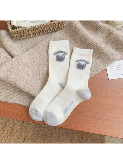 Ivory crew socks with fuzzy cat-face motifs and gray toes