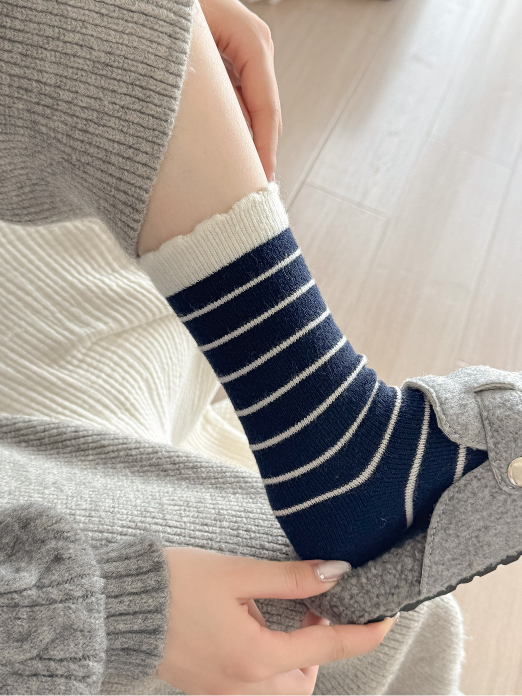 Navy striped crew sock worn with a gray slipper