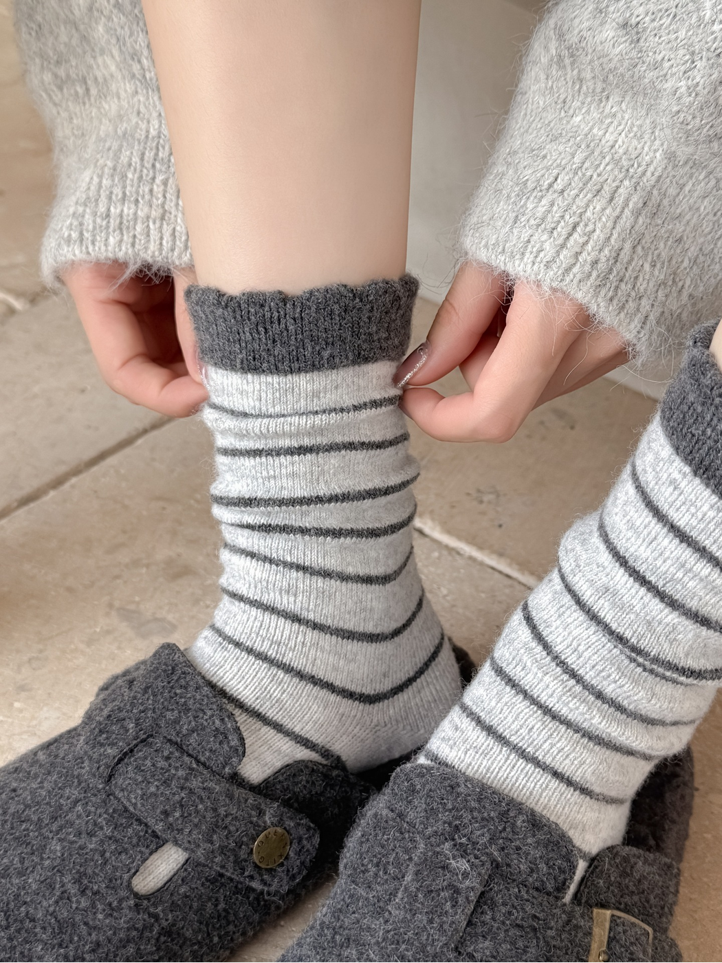 Close-up of the light gray striped sock cuff and fuzzy texture