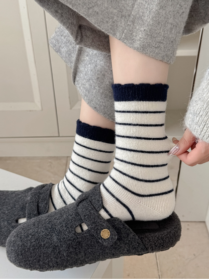Ivory striped crew socks worn with gray slippers