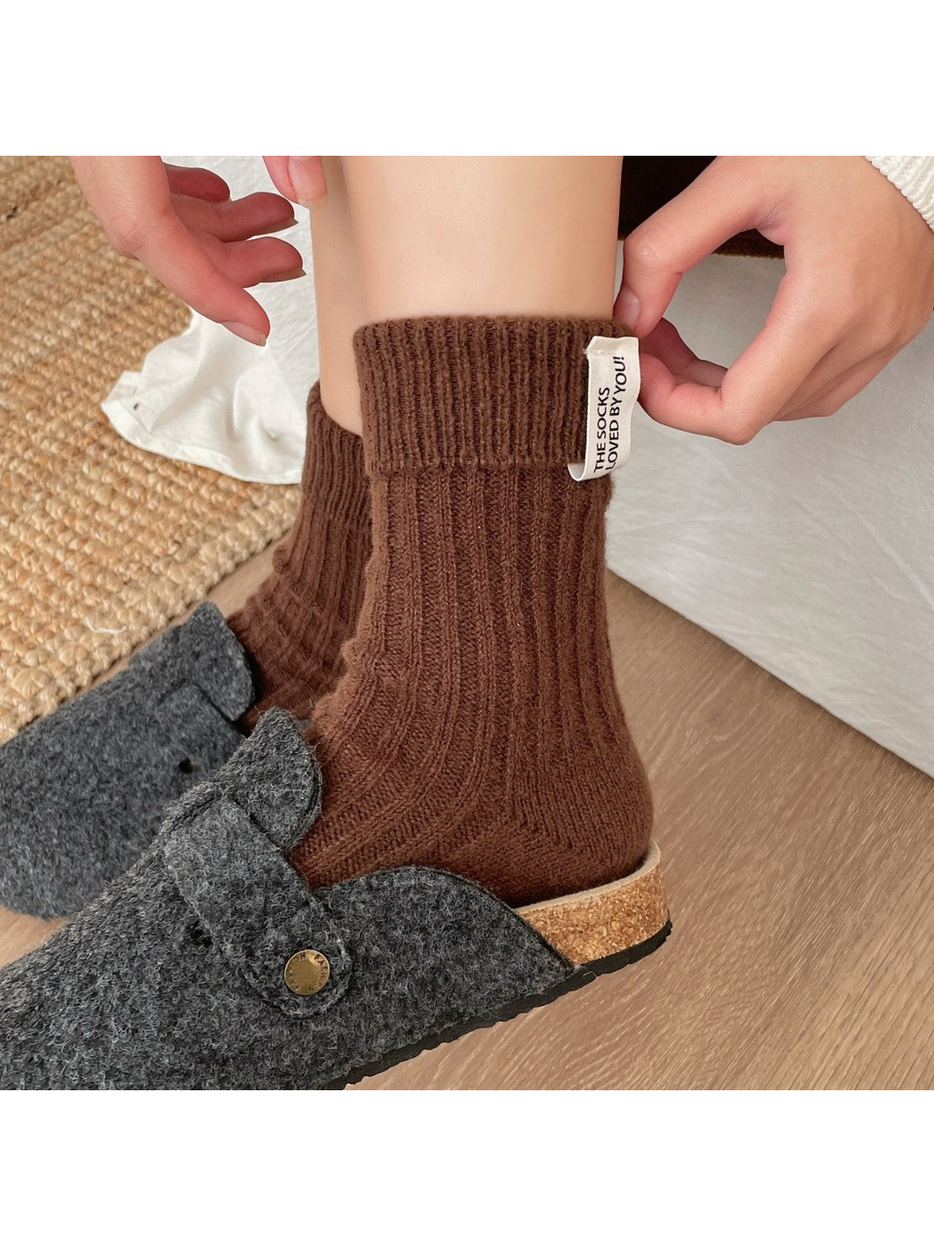 Close-up of a brown ribbed crew sock with folded cuff and fabric label