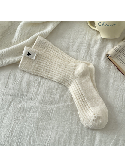 Cream ribbed crew socks with a heart label