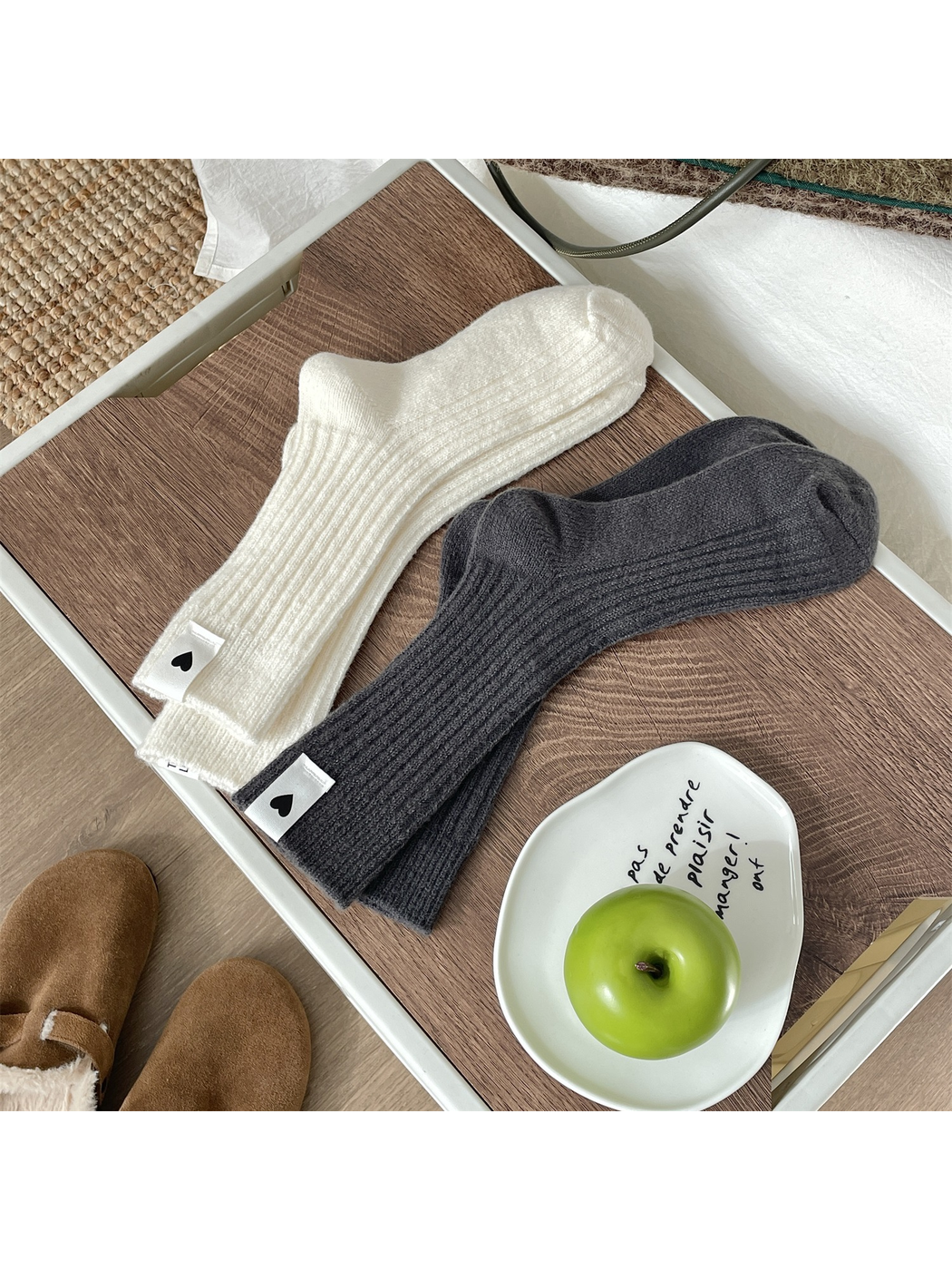 Cream and dark gray ribbed crew socks arranged on a wooden tray