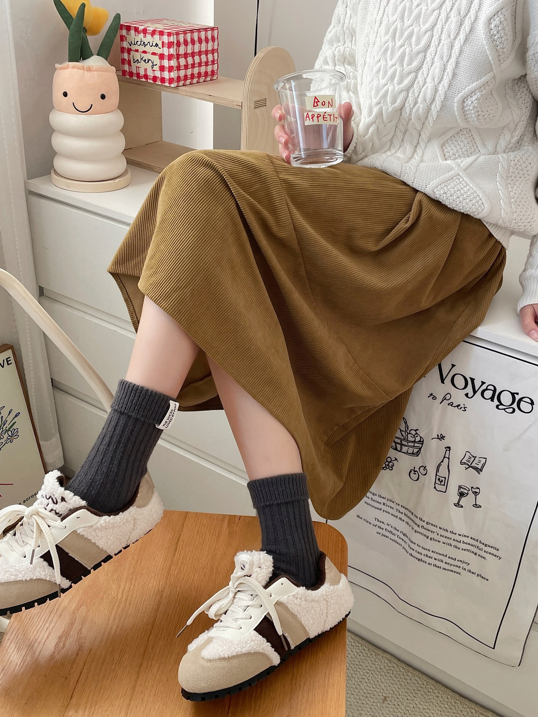 Dark gray ribbed crew socks styled with lined sneakers and a corduroy skirt