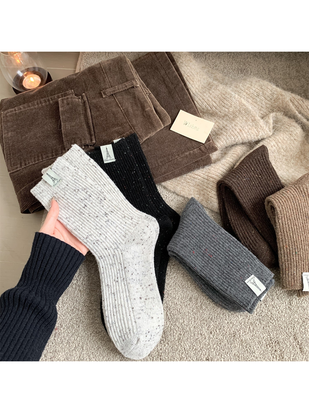 Neutral ribbed crew socks in five speckled colors arranged with winter clothing