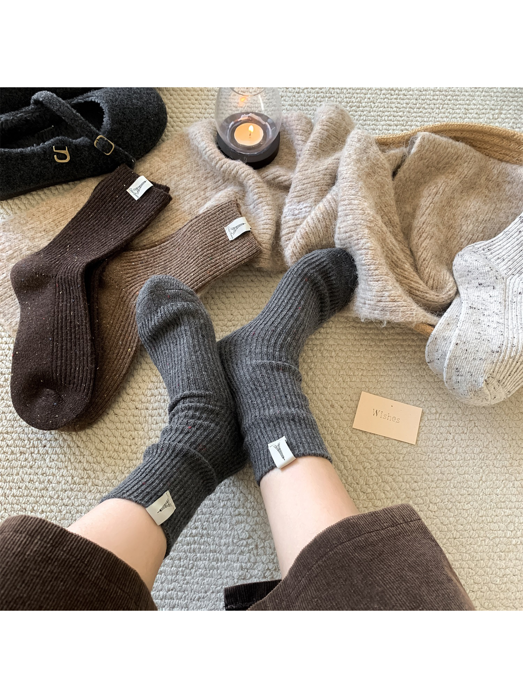Dark gray speckled crew socks worn in a relaxed indoor setting with other colors nearby