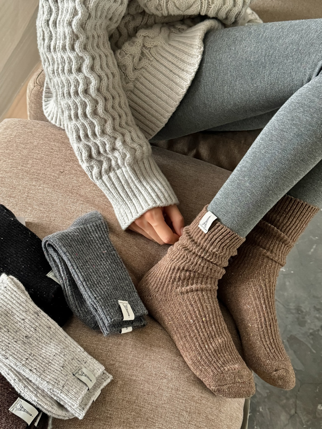 Camel speckled crew socks worn with gray leggings beside folded color options