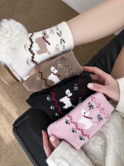 Black, brown, ivory and pink dog-motif fuzzy socks displayed together in a lifestyle setting