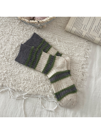 Cream and dark gray crew socks with green fuzzy stripes