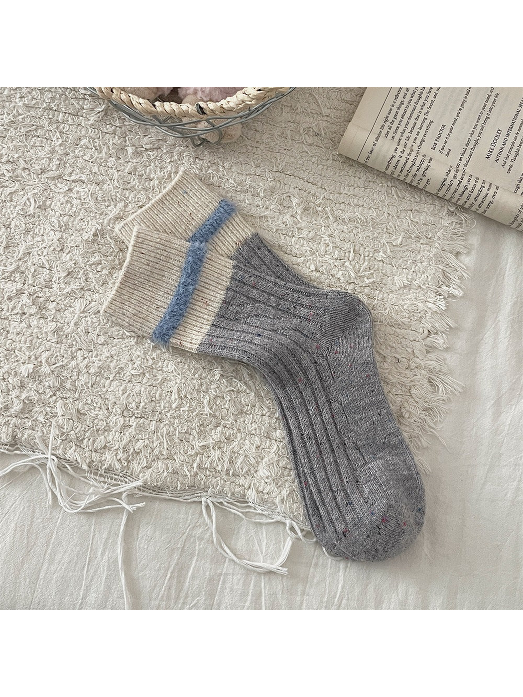Gray speckled crew socks with cream cuffs and blue fuzzy trim