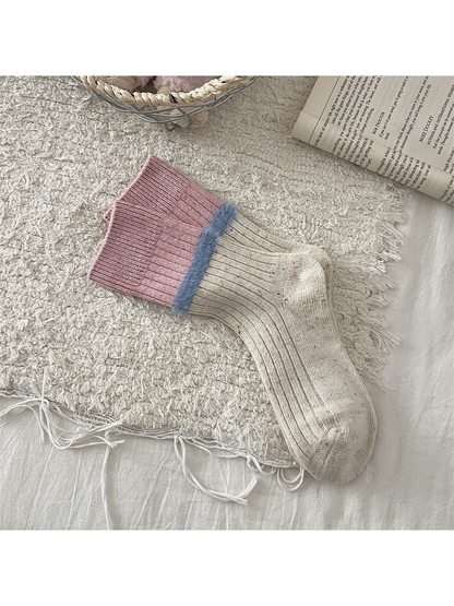 Cream speckled crew socks with pink cuffs and blue fuzzy trim