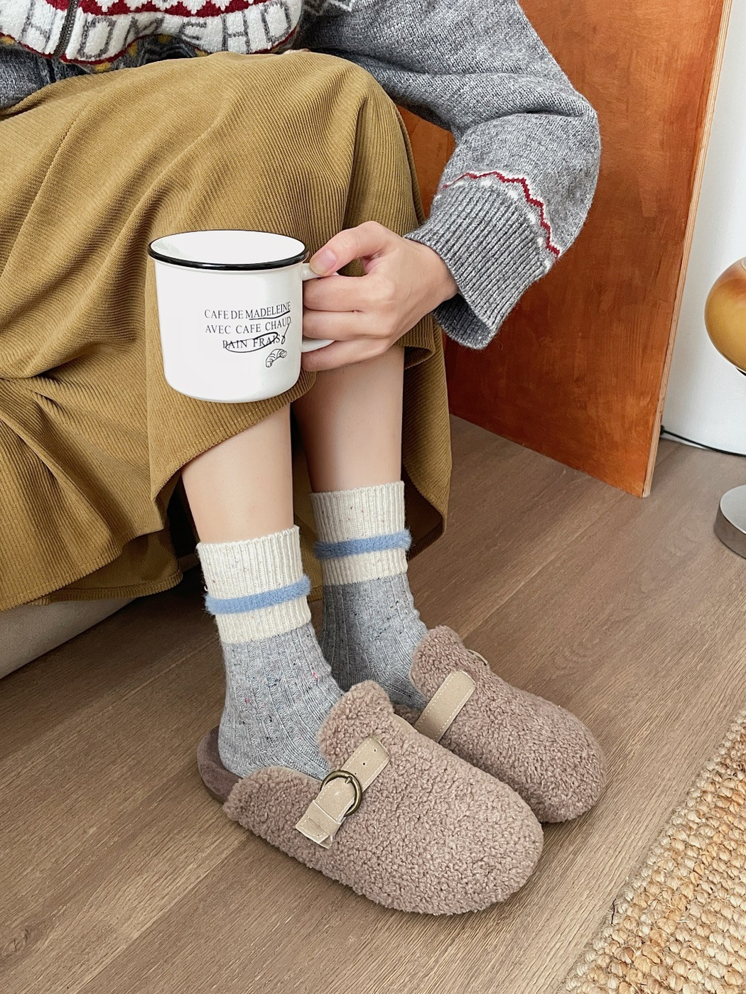 Gray speckled crew socks with cream cuffs worn with fuzzy clogs