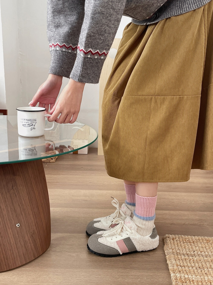 Cream and pink crew socks with blue fuzzy trim worn with sneakers