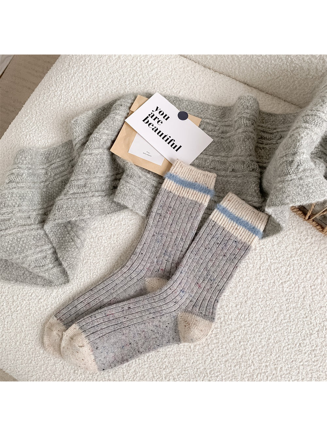 Gray ribbed crew socks with ivory cuffs and pale blue fuzzy bands