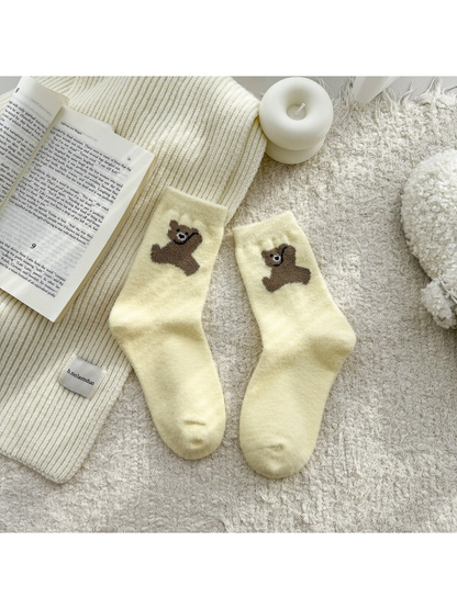 Pale yellow fuzzy socks with brown bear motifs