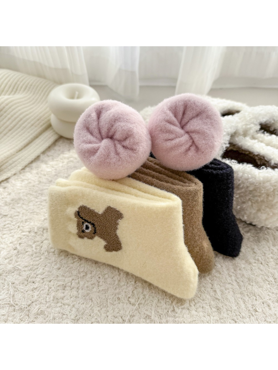 Rolled pink socks displaying the rounded toe construction beside folded animal-motif styles