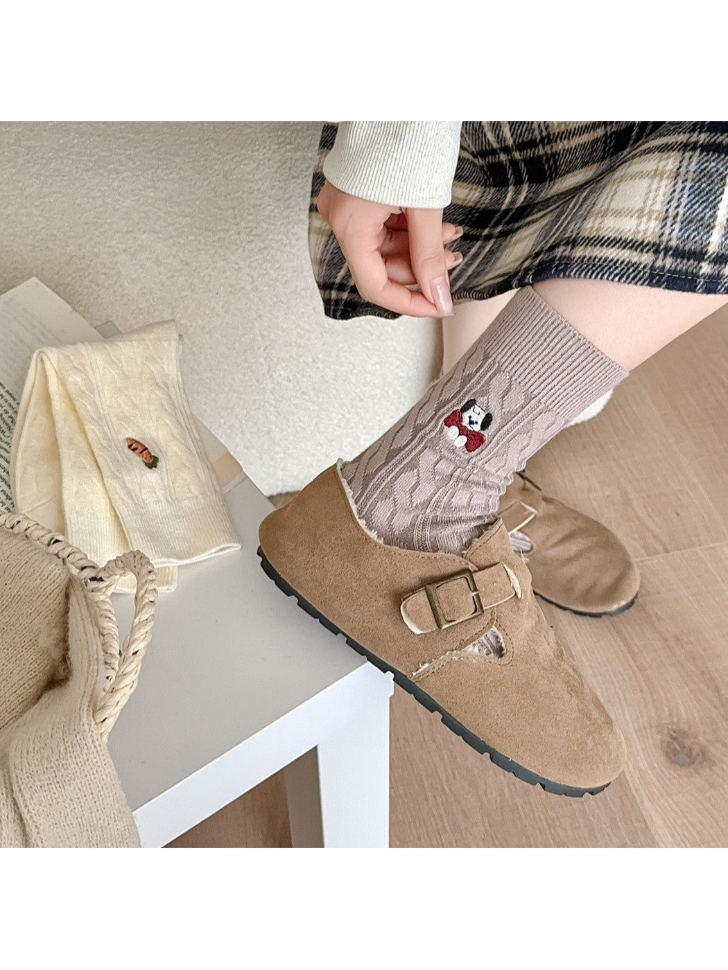 Light taupe cable-knit crew socks worn with tan clogs