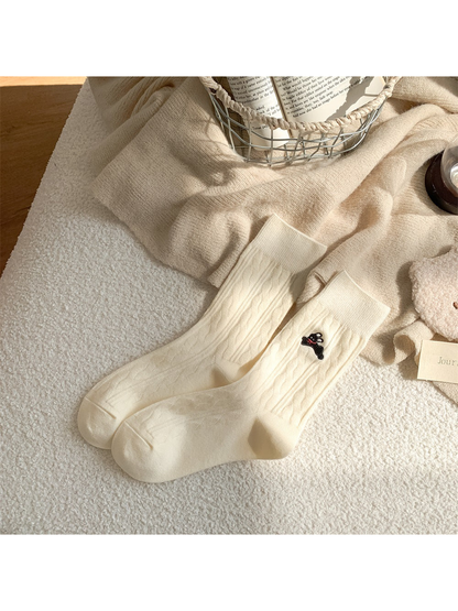 Ivory cable-knit crew socks with embroidered black rabbit