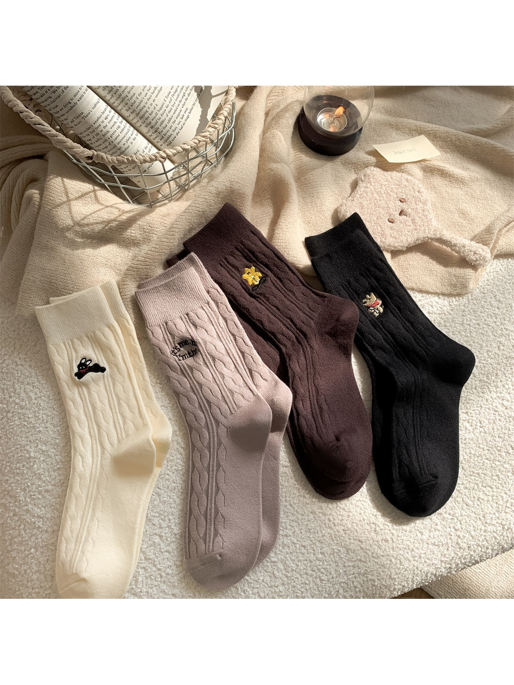 Ivory, light taupe, dark brown and black cable-knit crew socks arranged together
