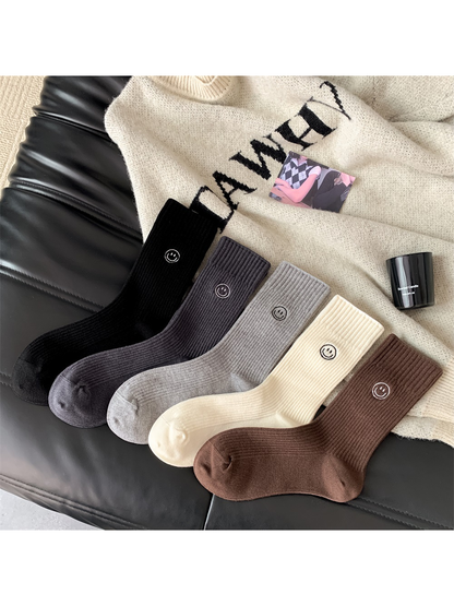 Five color variants of ribbed crew socks with embroidered smiley motifs