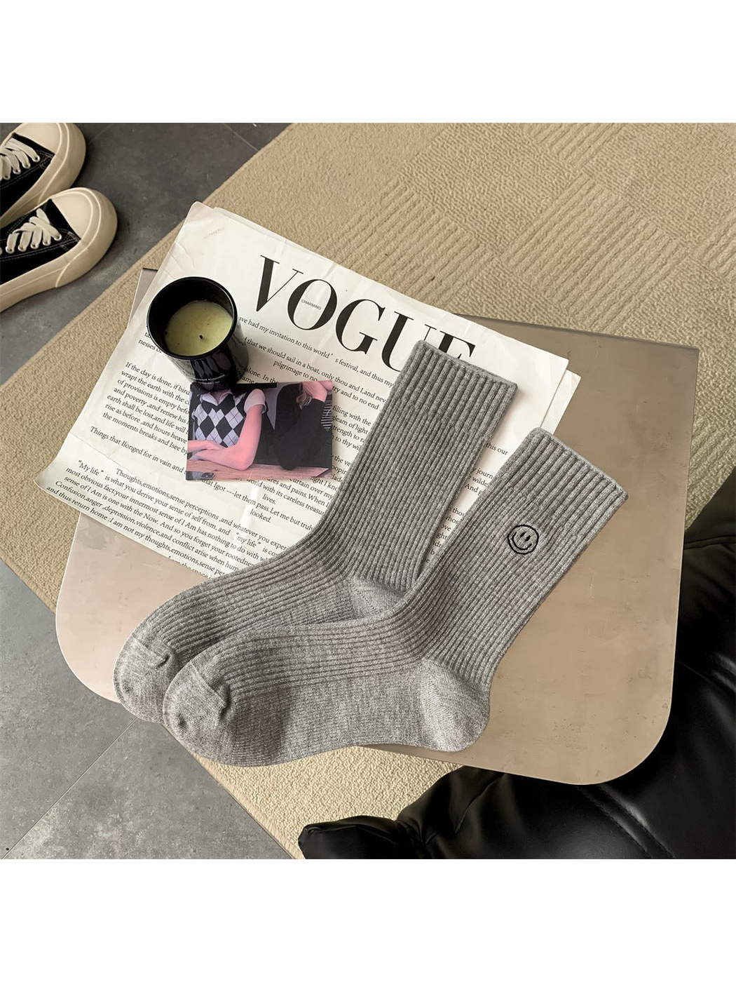 Light gray ribbed crew socks with embroidered smiley motif, pair laid flat