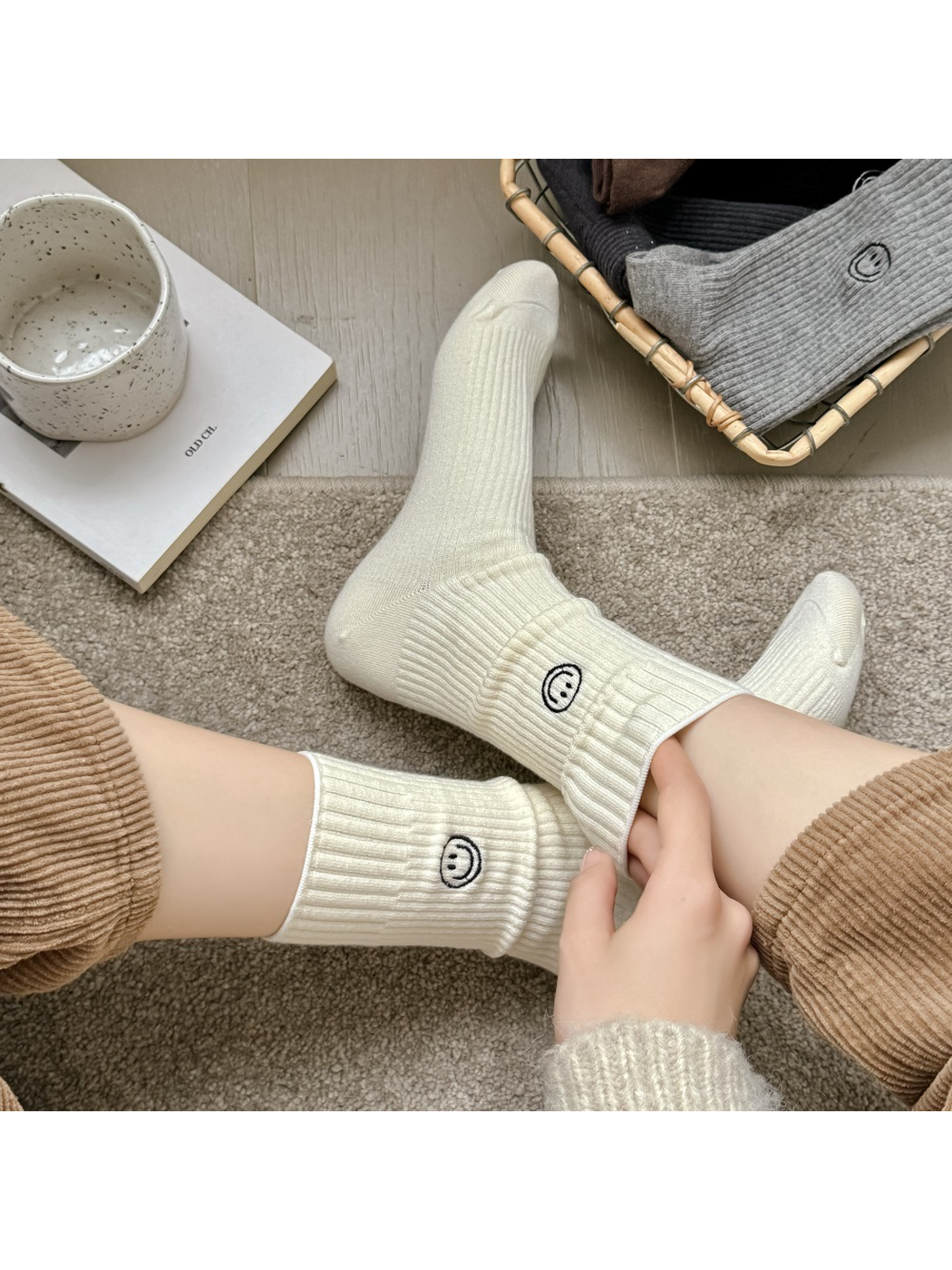 Cream ribbed smiley crew socks worn without shoes in a seated view