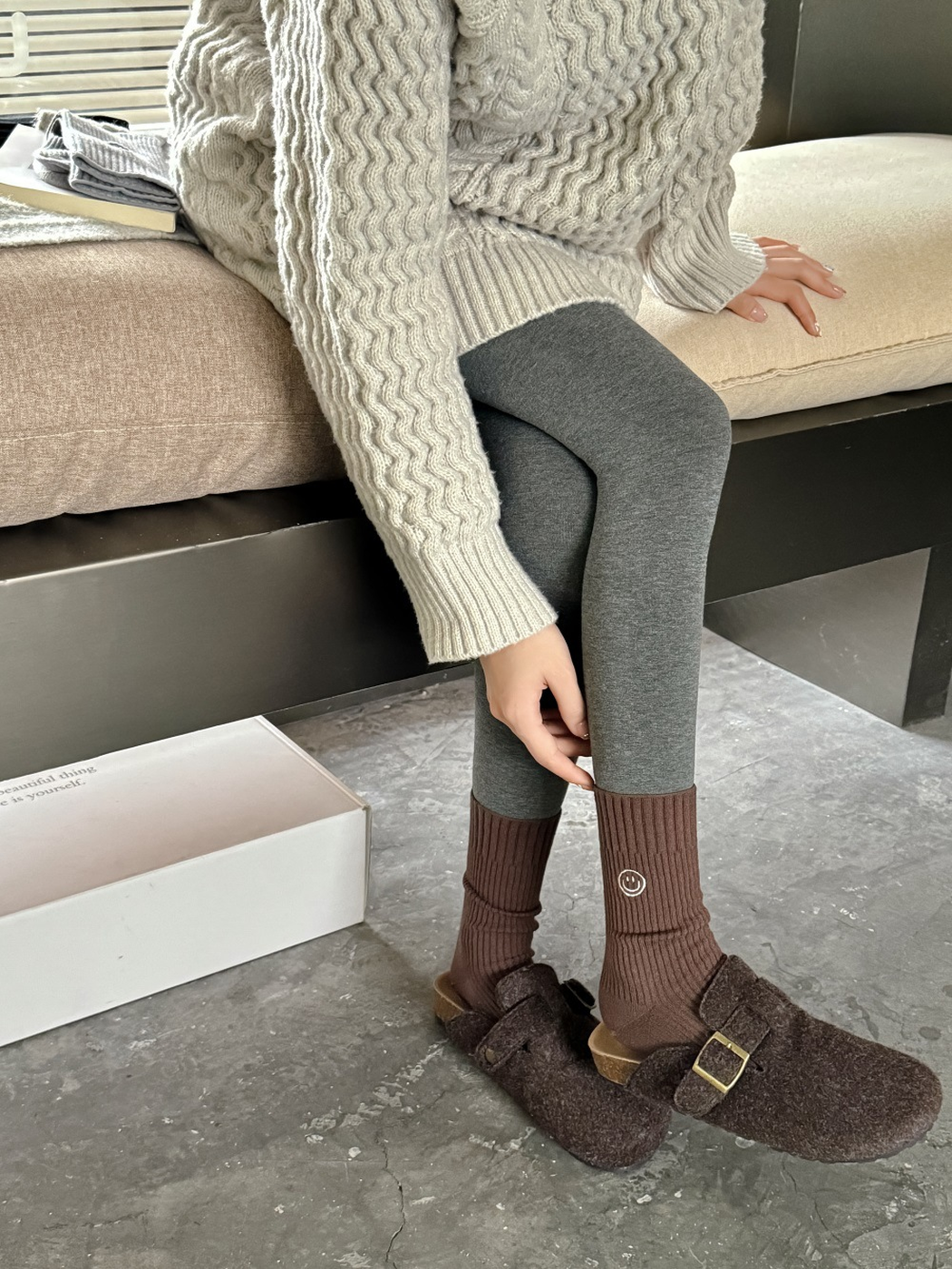 Brown ribbed smiley crew socks worn with dark leggings and brown clogs