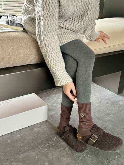 Brown ribbed smiley crew socks worn with dark leggings and brown clogs