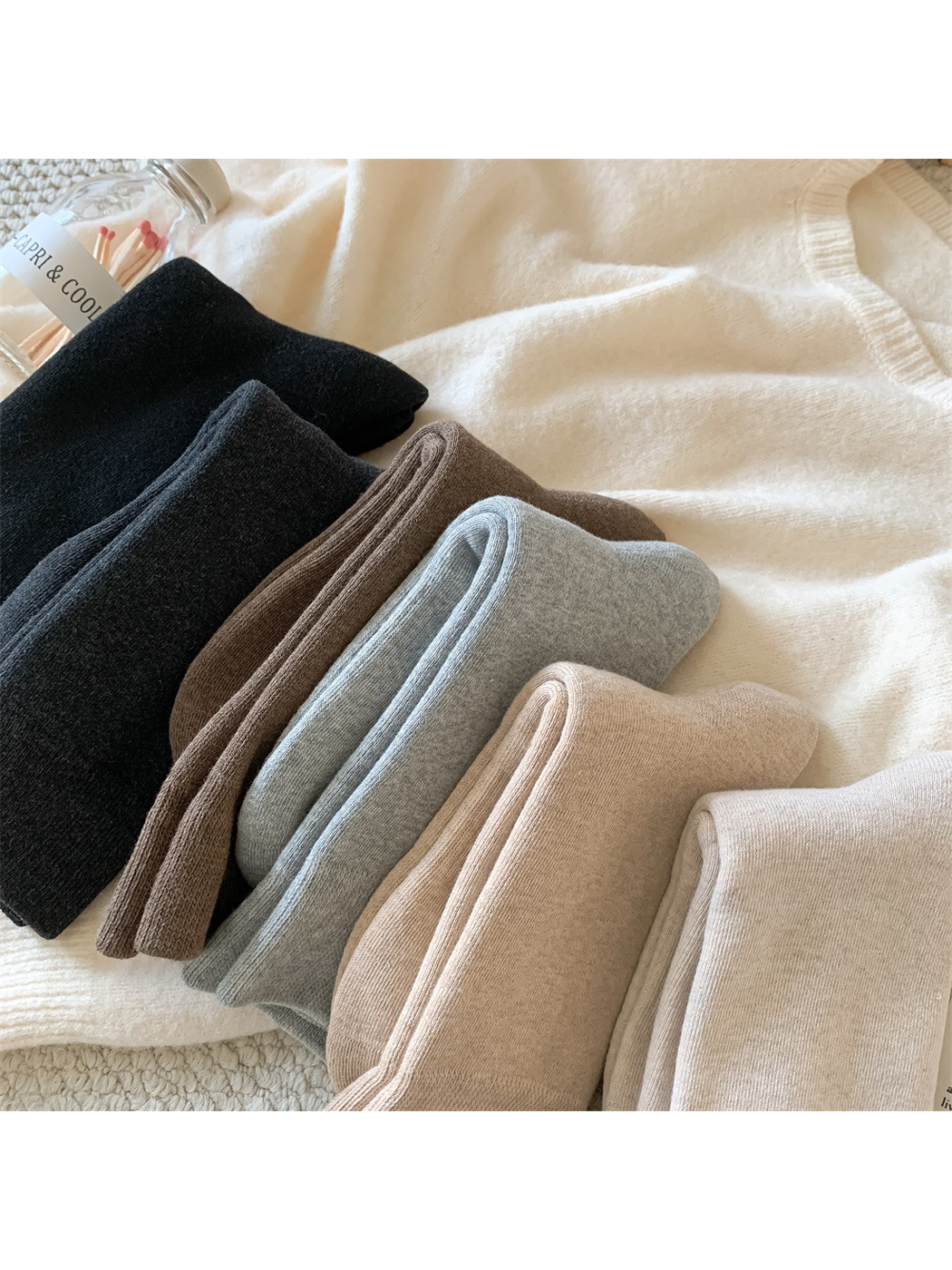 Folded solid-color crew socks arranged in six neutral shades