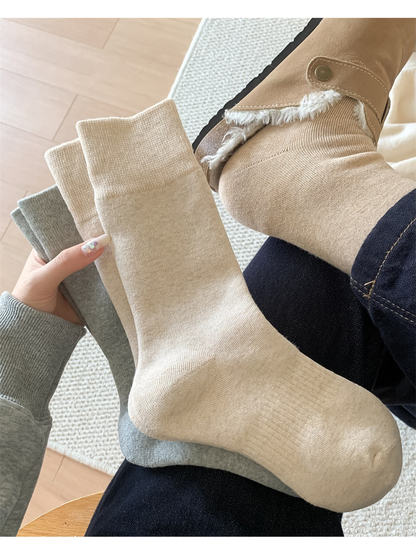 Beige crew sock worn above a lined ankle boot