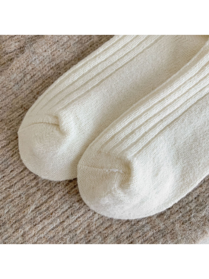 Close-up of the rounded cream sock toes and seams
