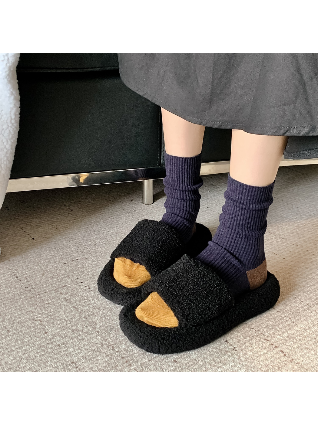 Navy ribbed crew socks with mustard toes worn with black slippers