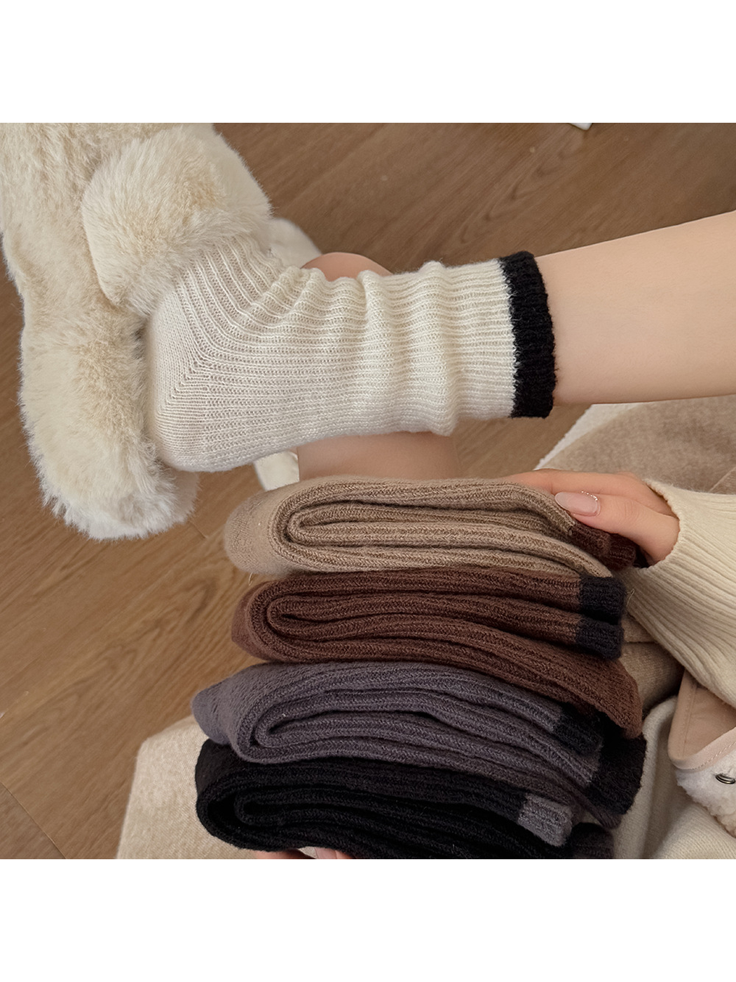 Ivory crew sock worn beside folded camel, brown, dark gray and black pairs