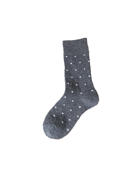 Dark gray crew sock with contrasting polka dots on a white background