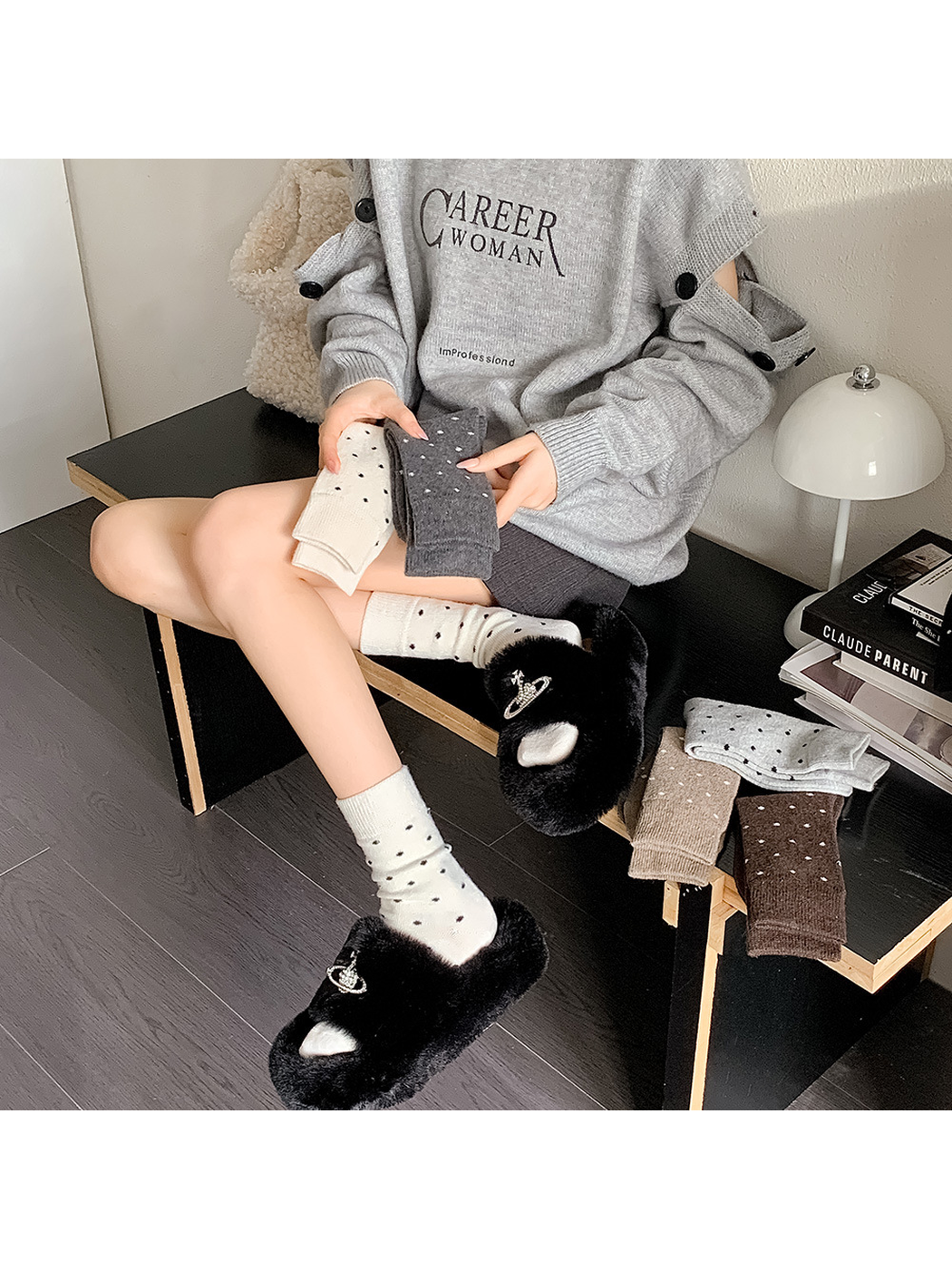 Cream polka-dot crew socks worn with black plush slides in an indoor scene