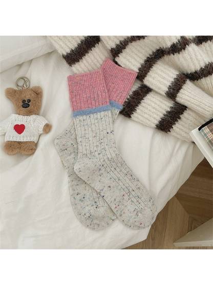 Ivory speckled crew socks with pink cuffs and light blue fuzzy bands