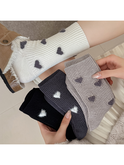 Heart-motif crew socks displayed in ivory, black and gray colorways