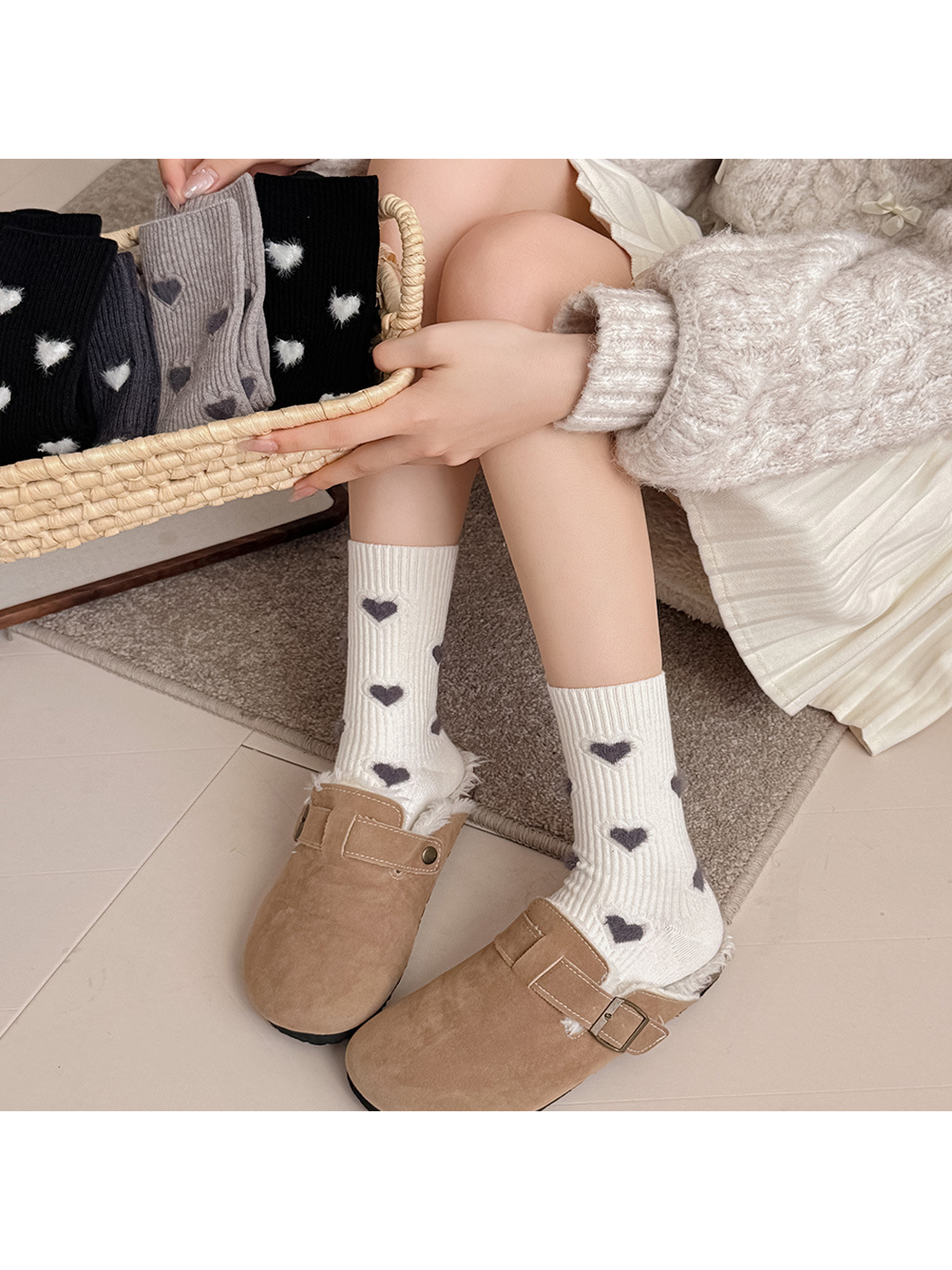 Ivory heart-motif crew socks worn with tan clogs beside assorted colorways