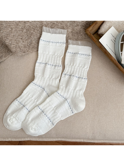 White crew socks with pointelle stripes and sheer ruffle cuffs
