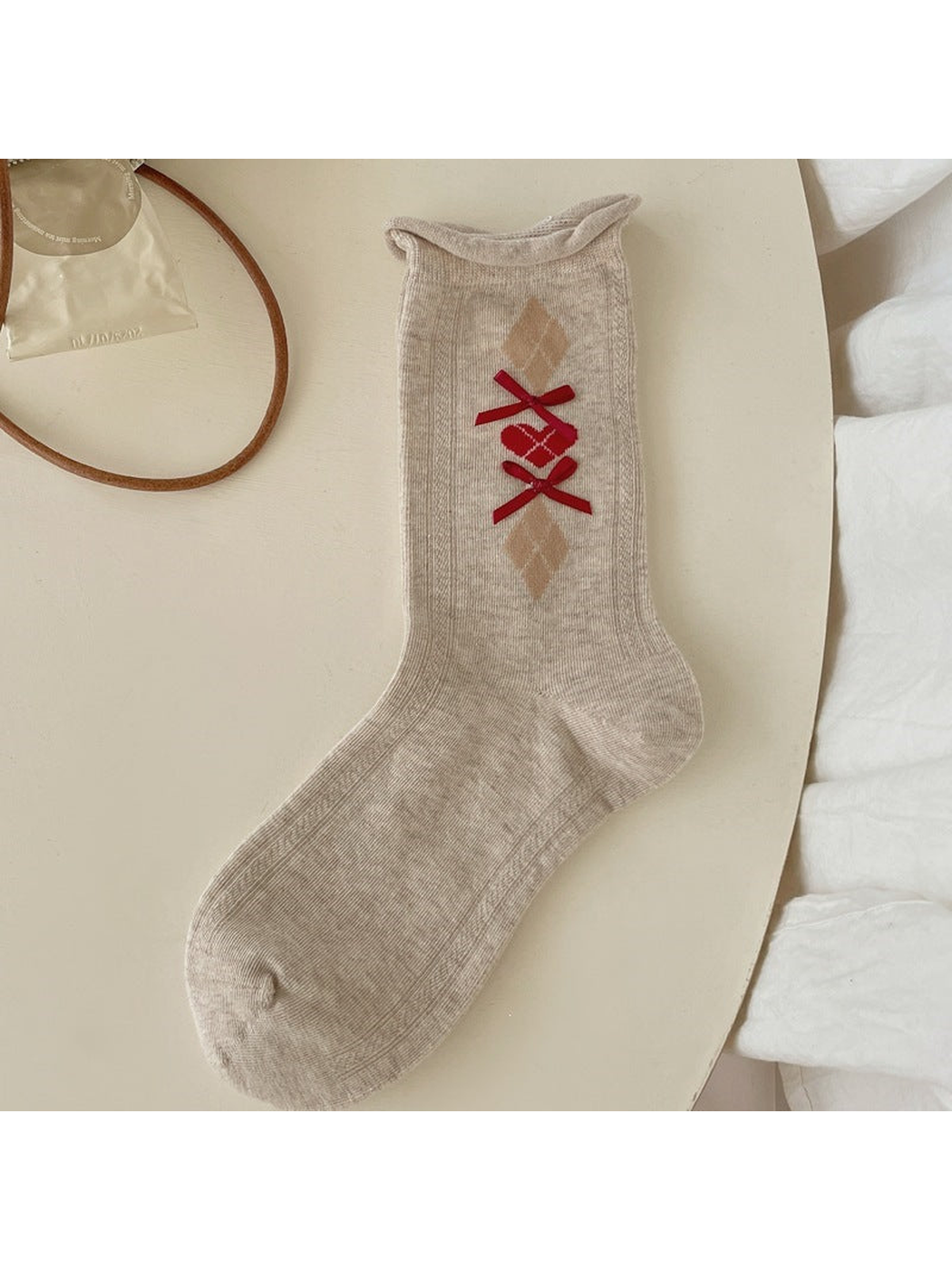 Beige ribbed crew sock with argyle diamonds and red ribbon bows