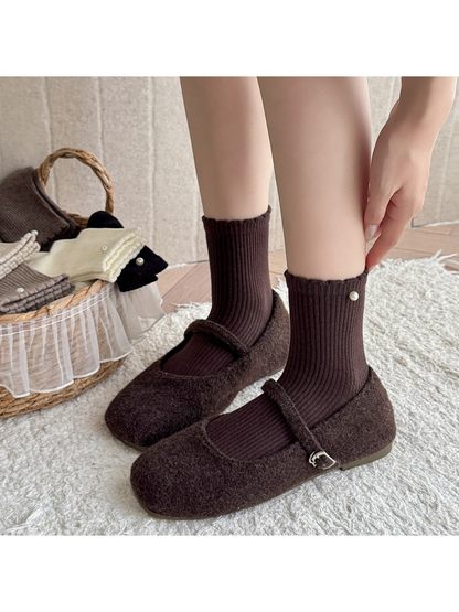 Dark brown ribbed crew socks styled with brown Mary Jane shoes