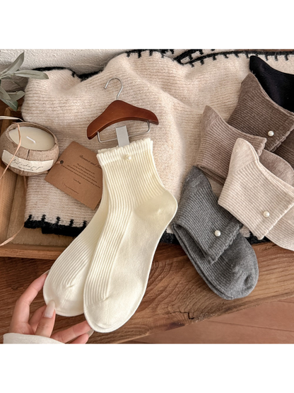 Ivory and neutral ribbed crew socks displayed with pearl-like accents