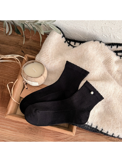 Black ribbed crew socks with a pearl-like cuff accent