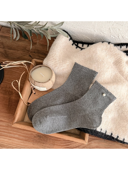 Dark gray ribbed crew socks with a pearl-like cuff accent