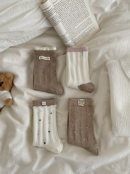 Four ribbed crew sock styles in ivory and light coffee arranged together
