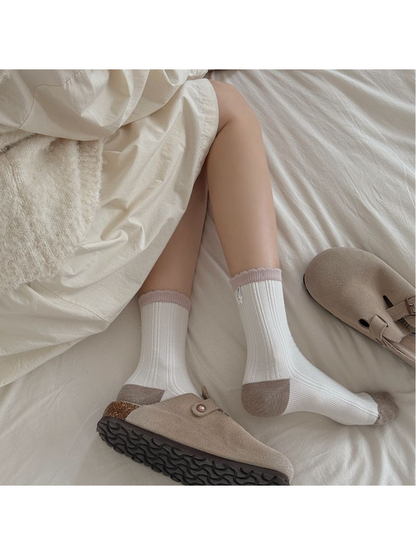 Ivory ribbed socks with contrasting toes, heels and pink cuffs styled with taupe clogs