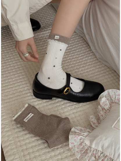 Ivory dotted ribbed socks worn with black Mary Jane shoes