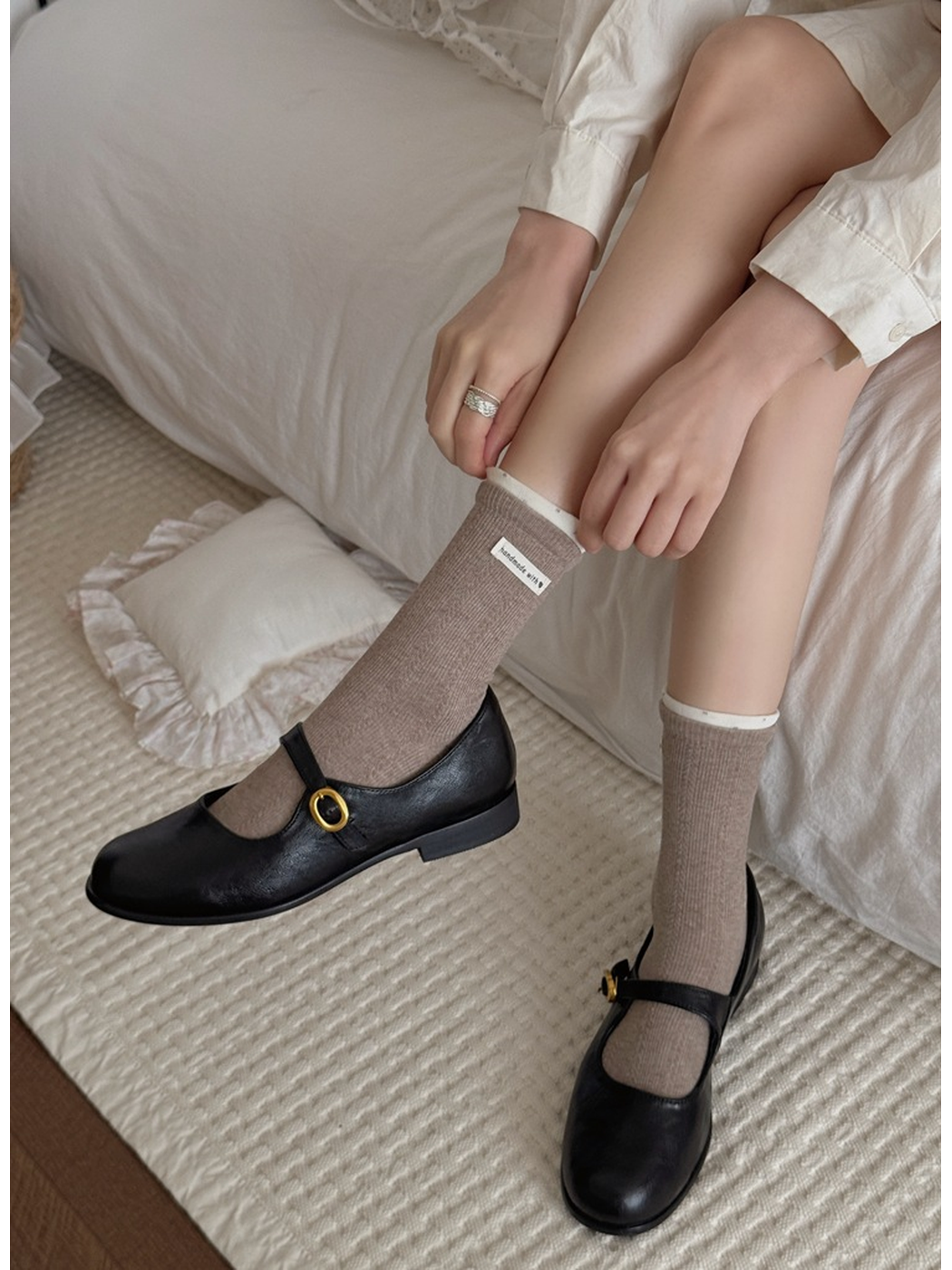 Light coffee ribbed socks with cream cuff edges worn with black Mary Jane shoes