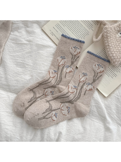 Beige crew socks with branching tulip pattern and blue ruffled cuffs